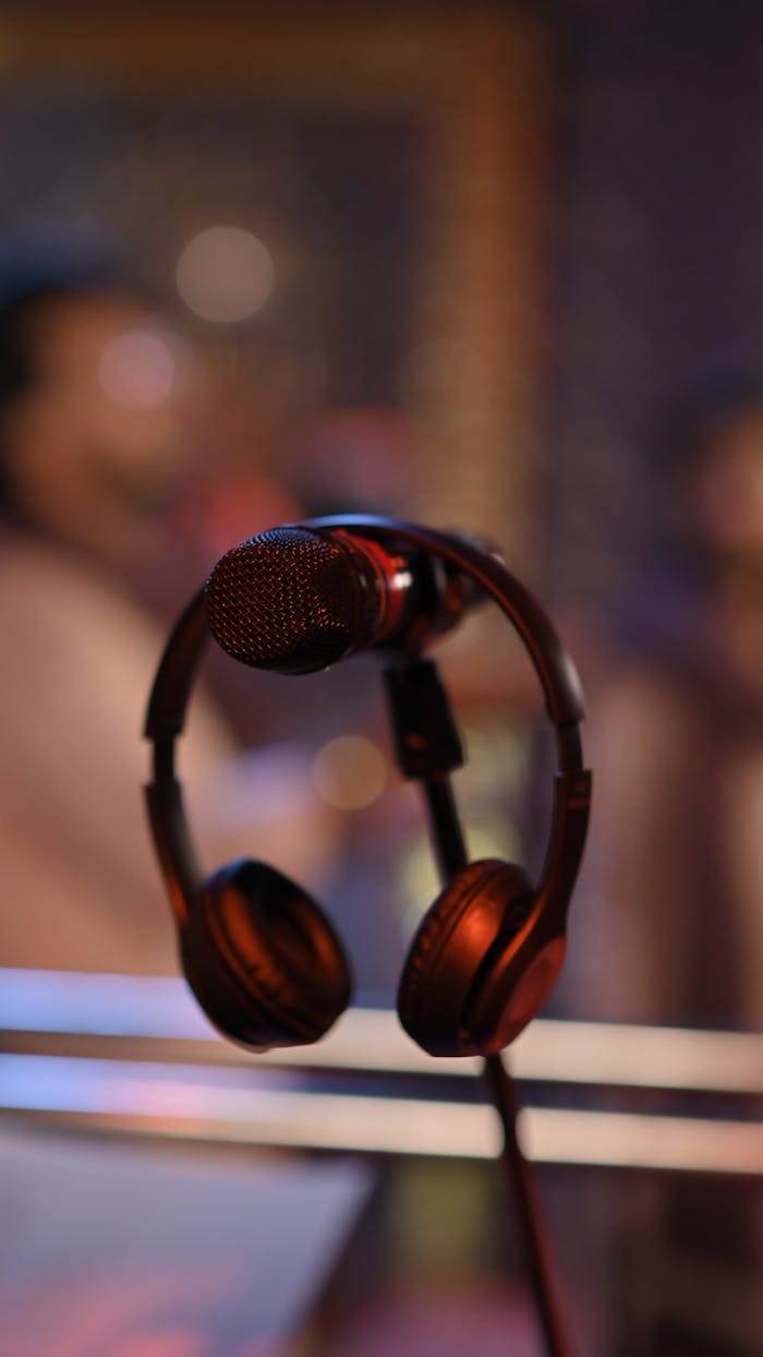Close-up of a microphone and headphones in a music studio setting creating a professional audio atmosphere.