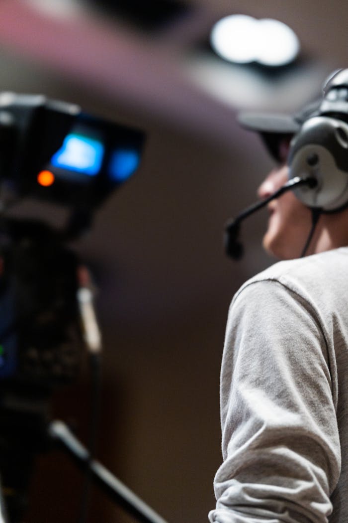 Professional cameraman capturing live events using a broadcast camera and headset.
